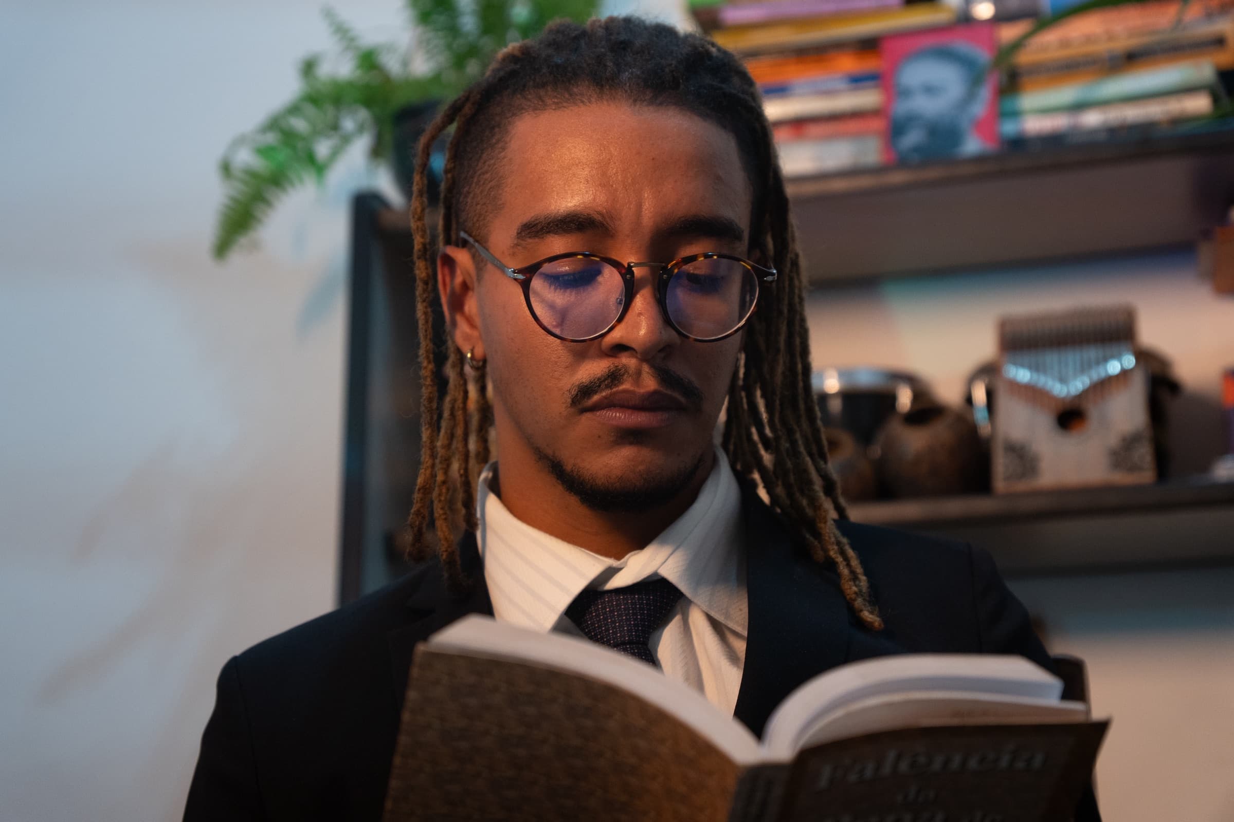 Thiago Farias lendo um livro em seu escritório